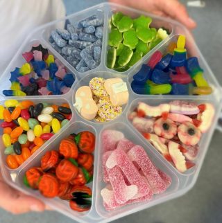 large sweet platter being held. nine different types of sweets.
